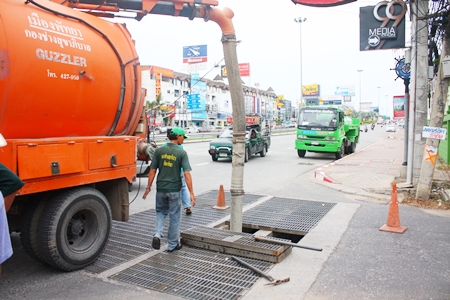 Pattaya officers use a giant vacuum pump to suck sand up out of the drainage pipes near the Father Ray Foundation.
